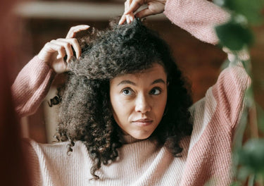 Lady looking at her hair in the mirror